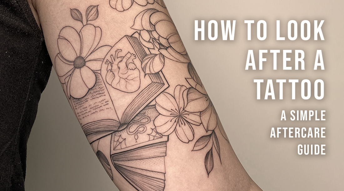 Blackwork floral sleeve tattoo with books and flowers by Toronto tattoo artist Lu Loram-Martin featured on a “How to Look After a Tattoo” aftercare guide.