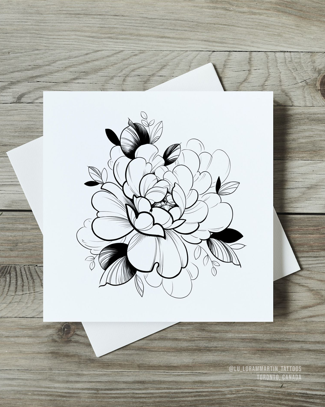 Floral tattoo design art print on a white card with a white envelope on a wooden surface