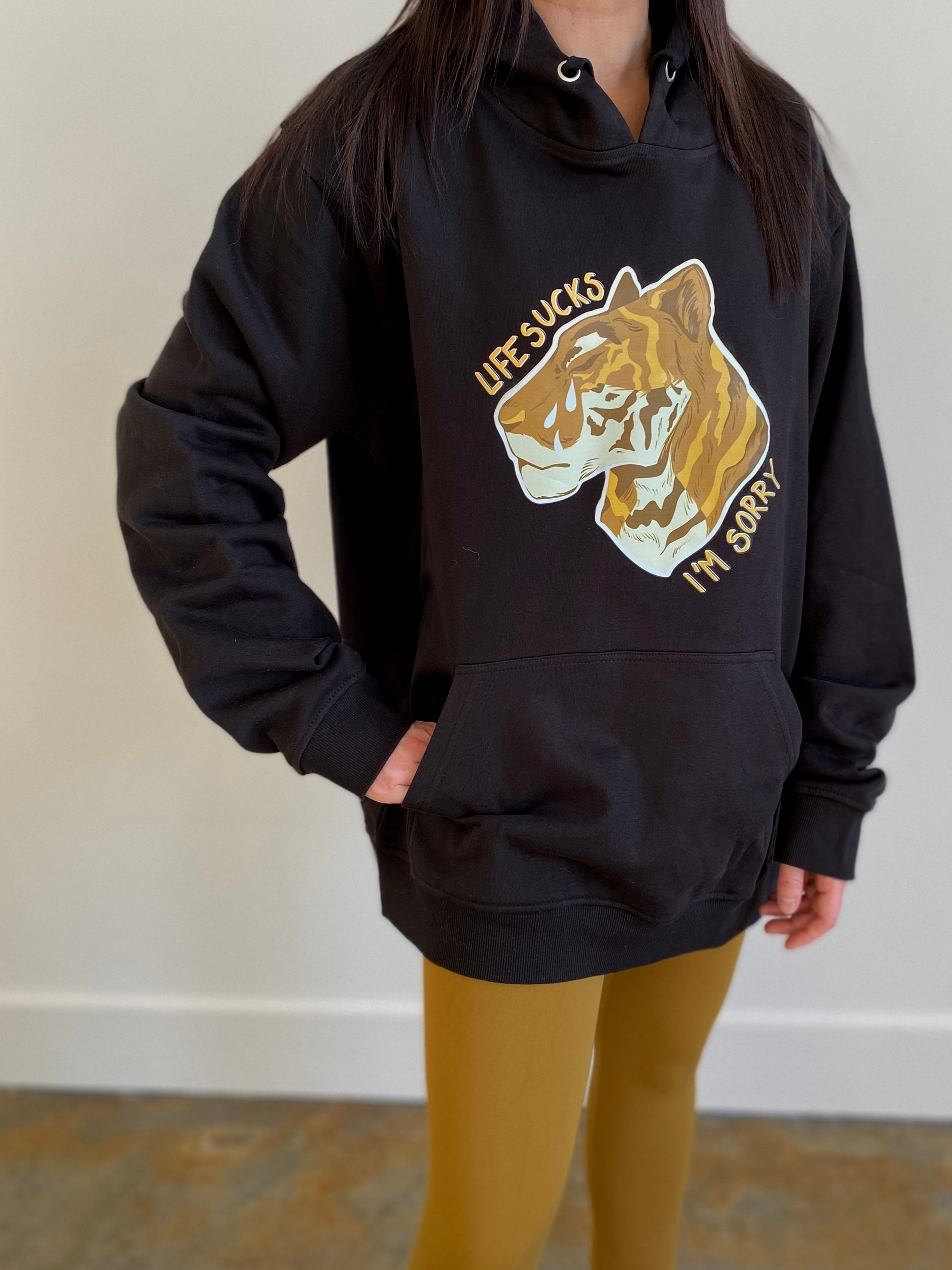 "Life sucks, I'm sorry" gold tiger design on black hoodie designed and illustrated by floral tattoo artist Lu Loram Martin, in Toronto, Canada.