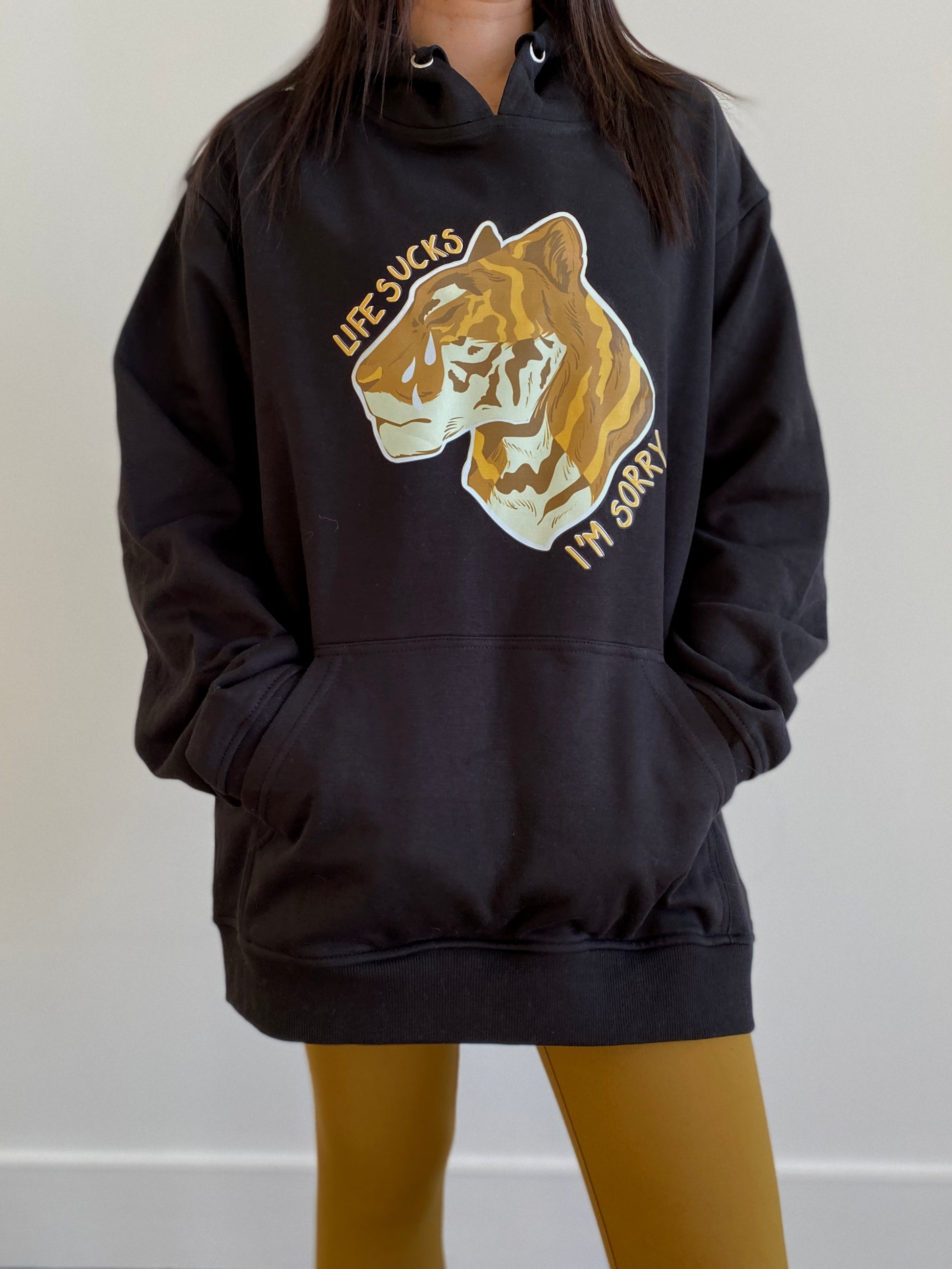 "Life sucks, I'm sorry" gold tiger design on black hoodie designed and illustrated by floral tattoo artist Lu Loram Martin, in Toronto, Canada.