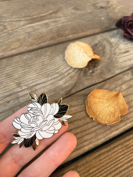 Floral enamel pin on hand, made by Lu Loram-Martin